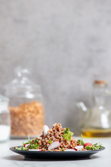 boiled buckwheat with radish and fork on a plate, vegetarian dish