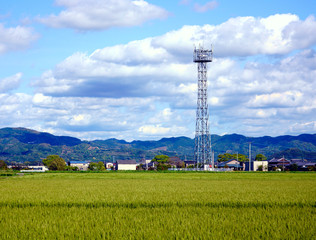 田園風景の中に建つ携帯電話の基地局鉄塔、携帯電話の基地局