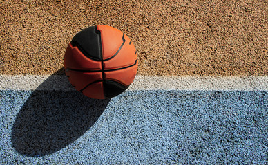 Basketball ball in a colorful street basketball court. Copy space.