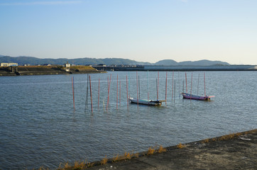 Fototapeta premium 九州の有明海にそそぐ矢部川 矢部川に係留された海苔船の夕景