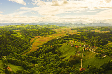 Aerial view of of green hills and vineyards with mountains in background