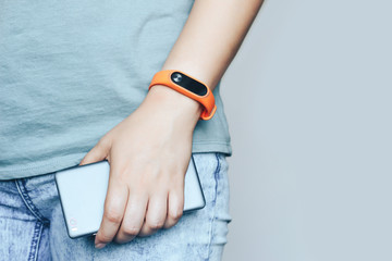 Woman with fitness tracker on her wrist is holding a phone. - 345209075