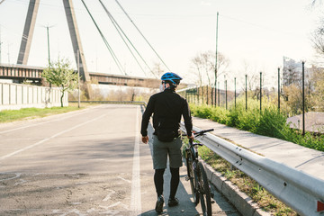 Cyclist in smog blanketed city in N95 mask. Air pollution. Industrial city. Man in mask from dust. Guy in respirator with filter pm 2.5. theme Covid 19. Smog, polluted toxic air, respiratory disease