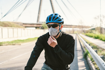 Cyclist in smog blanketed city in N95 mask. Air pollution. Industrial city. Man in mask from dust. Guy in respirator with filter pm 2.5. theme Covid 19. Smog, polluted toxic air, respiratory disease