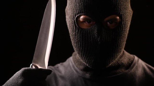 The robber hold the knife in hand