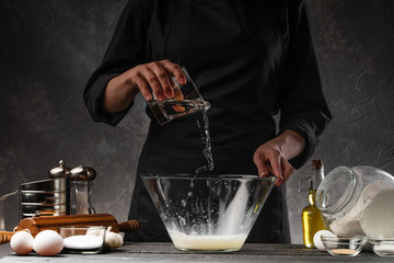 The chef prepares the dough on the water to prepare flour dough for sweets, rolls, donuts. Freezing...