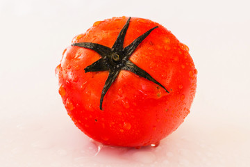 Fresh organic tomatoes with dew drops isolated on white background