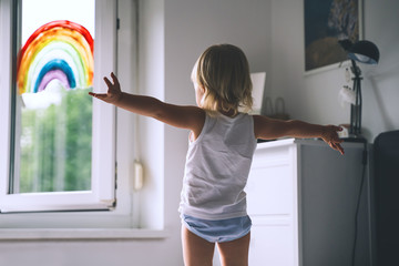 Cute little girl having fun time jumping on bed at home.