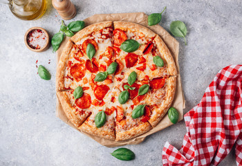 Pepperoni pizza with basil on a rustic background.