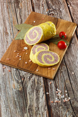 Rolled Stuffed Chicken Breast. Chicken or Turkey Roulade. Low Carb Chicken Roll Ups with cheese on a wooden table with addition of fresh herbs and aromatic spices. Natural product from organic farm.