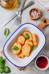 Hash brown or potato pancakes on plate with catsup on light gray background