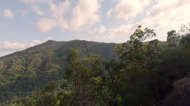 Kuranda Scenic Railway Train. Tourist train journey across rainforest and jungles in Cairns Australia. View of train, train tracks, passenger seats, interior, skyrail, bridge, mountains and landscape.