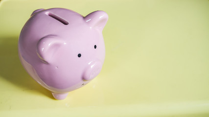 piggy bank is isolated in yellow background. saving money is an investment for the future.