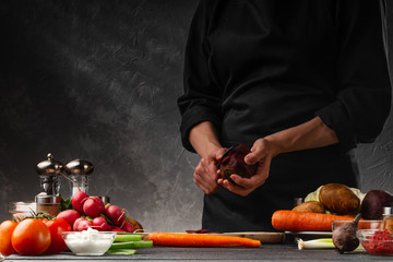 Chef cooks. Slices beets on a background of vegetables. Cooking and gastronomy. Recipe book and organic vegetables.