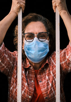 adult woman with a face mask looking out of the windows