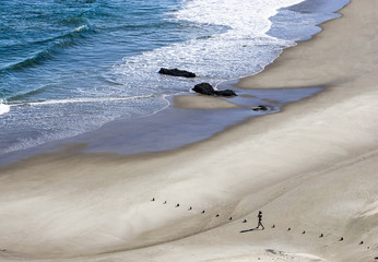Candid scene of a young man on a secluded remote beach building line of stones