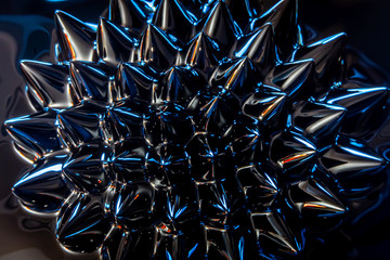Closeup of magnetized ferro-fluid, colorful, abstract, geometric pattern of liquid metal 