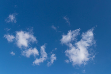 Dark blue sky with small fluffy clouds, horizontal photo