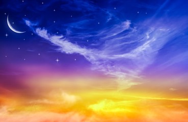 Obraz premium Young month amid sunset . Moon in bright clouds