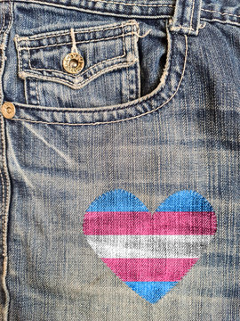 Jean with a transgender flag in a heart shape sewed in it.