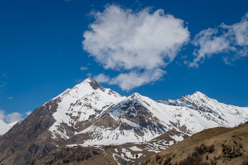 Beautiful mountain peaks of the Caucasus and a cloud above them. 
Landscape