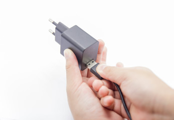 Connecting USB Cable to adapter charger for smartphone.
