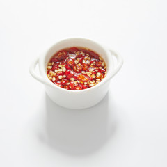 Thai Chili fish sauce in a white cup on white background