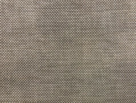 A close-up and macro photo a grey woven fabric that is visible to the details of the beautiful structure of the yarn which is suitable to be used as a background or wallpaper.
