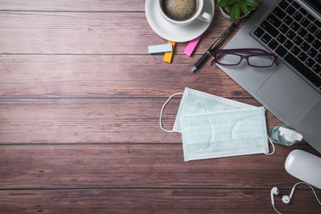 surgical face mask and sanitizer bottle or alcohol gel with laptop