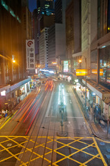 Fototapeta na wymiar HONG KONG, HONG KONG SAR - NOVEMBER 17, 2018: Light blur motion scene of tram and traffic in central Hong Kong at night. There are many pedestrians on the street.