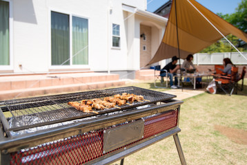家の庭でバーベキューをする家族