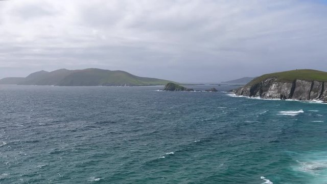 Panning shot showing Blasket islands in Atlantic ocean near Irish Dingle peninsula coast.