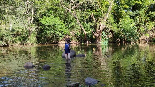 Caucasian and Brazilian boy playing in freshwater stream
