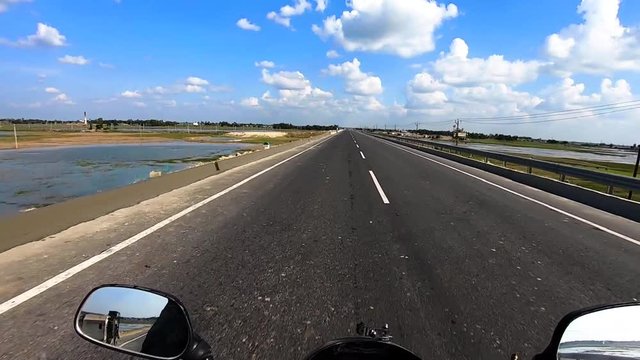 motorcycle ridding on tarmac road with amazing blue sky and cloud patch
