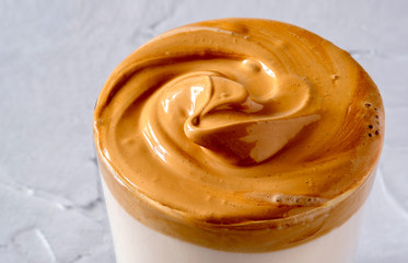 Dalgona Coffee. Milk topped with whipped instant coffee.