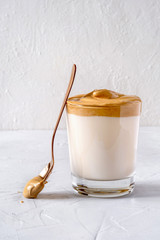 Dalgona Coffee. Milk topped with whipped instant coffee.