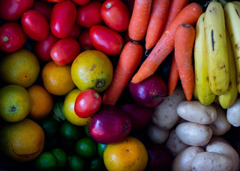 A group of fruits and vegetables in a box, organized by its type and colour