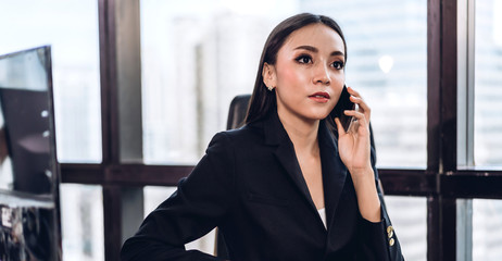 Portrait of smiling happy beautiful asian woman relaxing using digital smartphone.Young asian girl talking with friend on phone at office