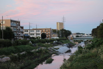 Fototapeta na wymiar 夕焼けの川と町並み