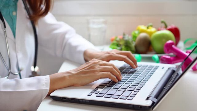 Nutritionist giving working on laptop and consultation to patient with healthy fruit and vegetable, Right nutrition and diet concept
