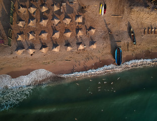 Aerial view of amazing beach with umbrellas and turquoise sea at sunrise. Black Sea at Vama Veche, Romania