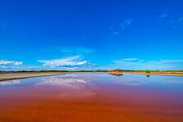 Salt barn with blue sky background in salt fields at Bang Tabun city of Petchaburi province, Thailand