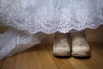 Bride wearing cowboy boots under wedding dress.