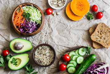 Healthy vegetarian diet food background with copy space. Red cabbage, avocado, tomatoes, cucumbers, pumpkin, wild rice on a light background, top view. Flat lay