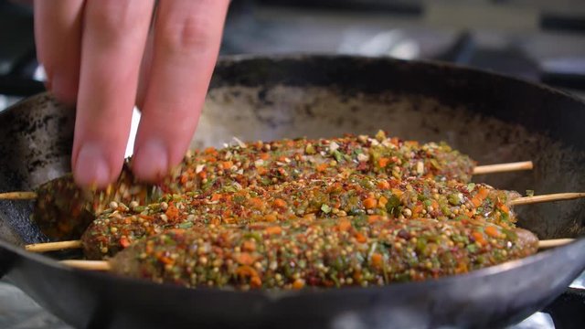 Lula kebab frying in a pan. The process of making lula kebab, a dish of Georgian cuisine. Closeup of cooking spice kebab lula.