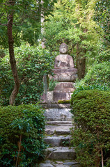 Stone Buddha statue in the forest garden of Ryoan-ji temple. Kyoto. Japan