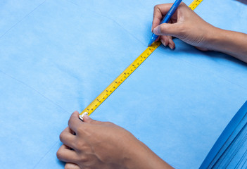 The size measurement for a making face masks from sterilization wrapping paper, close up. A homemade produce of masks to protect against dirt, smog and virus.