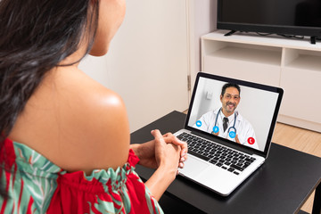 Woman using a laptop for a webcam online with a doctor at home