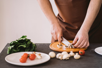 People cooking, homemade food. Closeup portrait of man making healthy dinner of vegetables and mushrooms