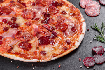 Pepperoni pizza with mozzarella cheese, salami, tomatoes, pepper and spices